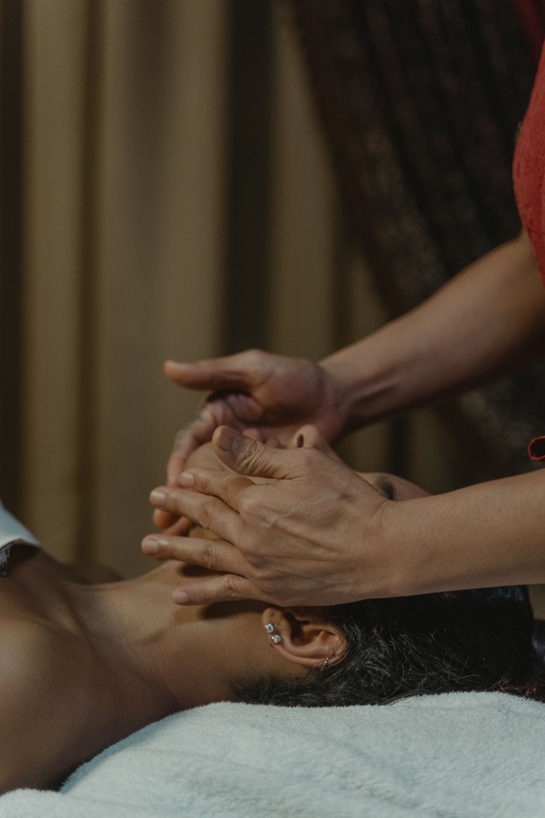 Hands performing a calming facial massage